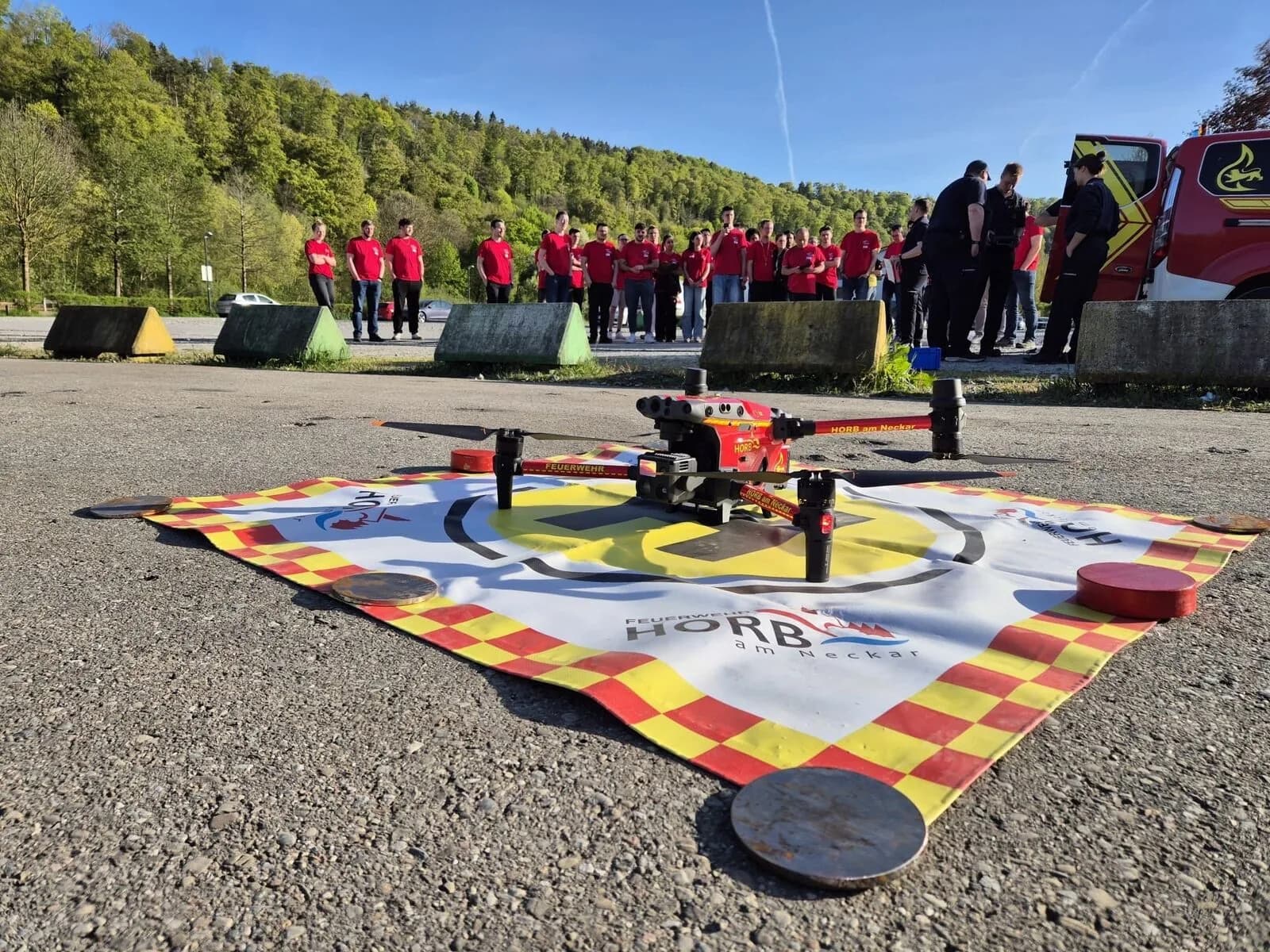 Einsatzdrohne der Feuerwehr Horb am Neckar auf dem Landeplatz, Teilnehmende schauen zu