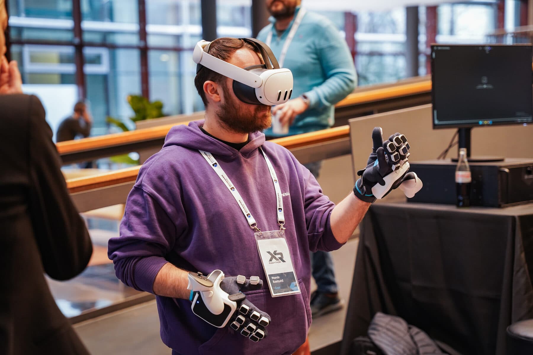 Visitor testing a VR headset with haptic gloves